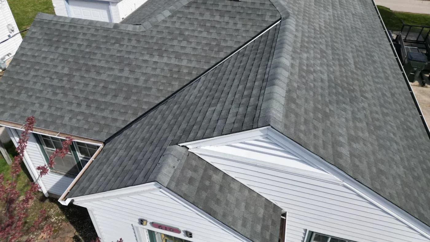 ALT: Aerial close-up of a residential home with gray asphalt shingle roofing and white siding in Menomonee Falls, Wisconsin.