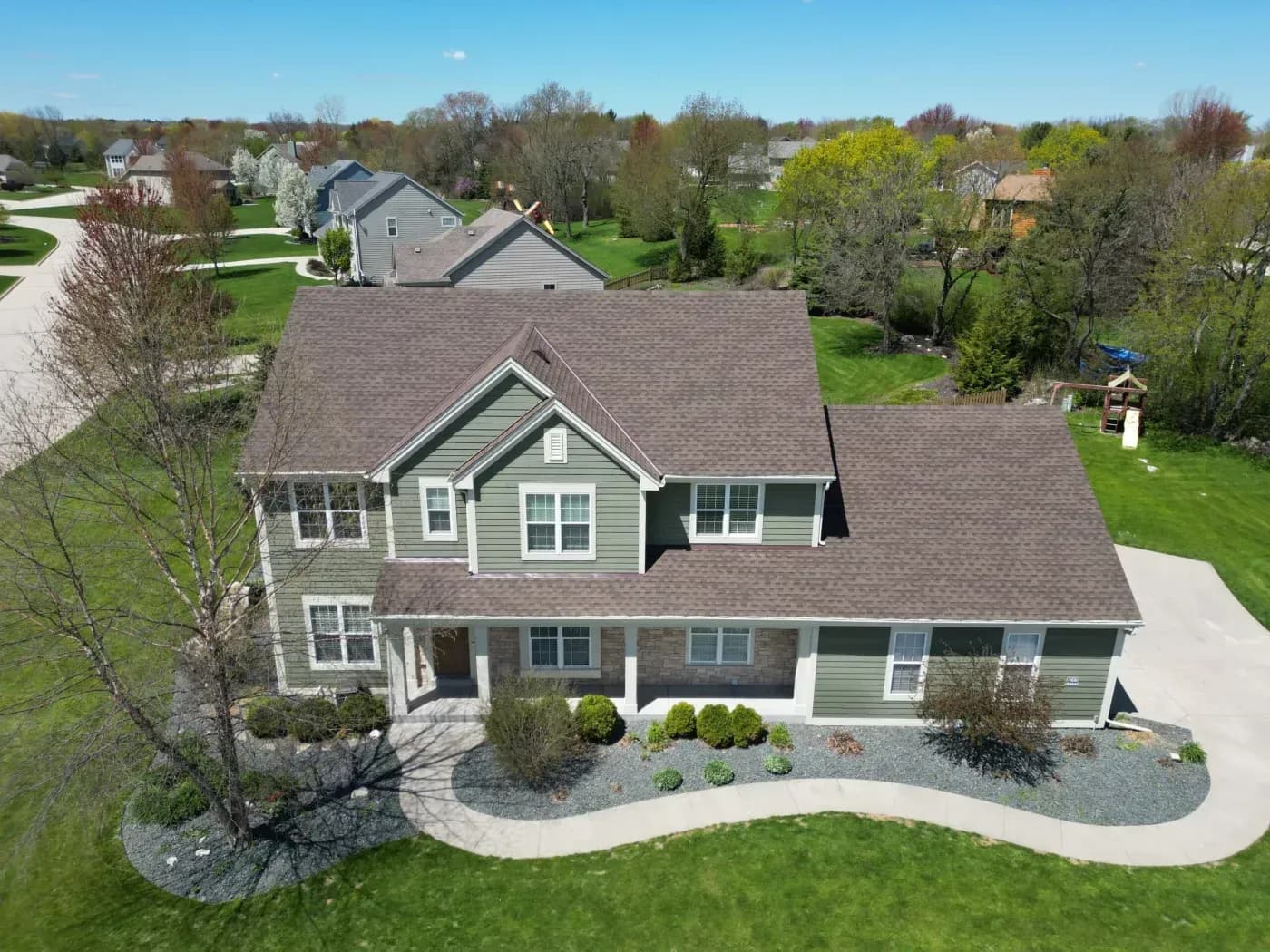 ALT: Aerial view of a two-story home with a weather-resistant asphalt shingle roof in Sussex, Wisconsin.